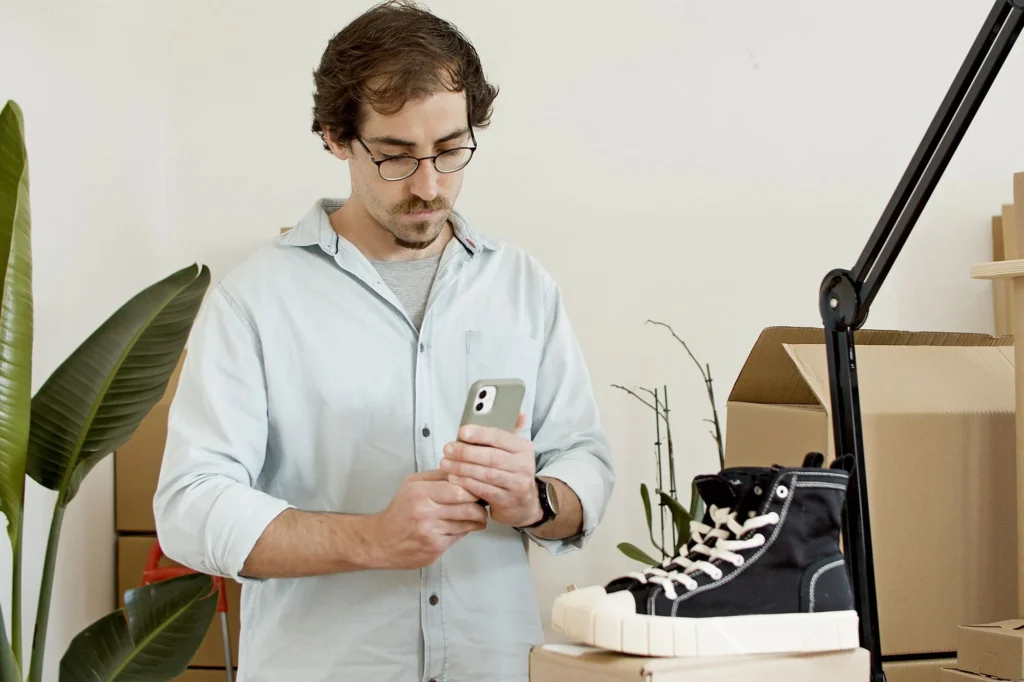 Business owner checking his phone in his shop